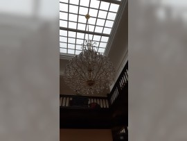 Interior oscuro de una villa con una lámpara de araña apagada