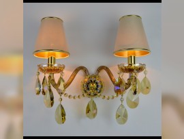 2-arm wall light made of plated colored glass with fabric shades lit