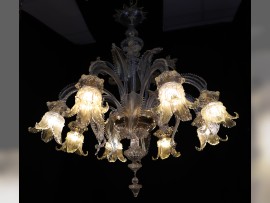 La luz resalta el tono dorado de las piezas de cristal de la lámpara de araña de época