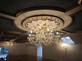 Espacios bajos del ático de una casa, decorados con gran lujo y con coloridas lámparas de araña de cristal