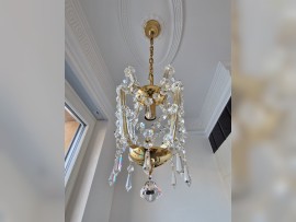 Una pequeña lámpara de araña estilo María Teresa en el cuarto de baño
