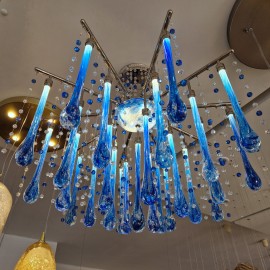 Variaciones de diseño de lámparas de araña modernas con gotas de cristal transparente y azul que reflejan la luz desde los sofitos del techo
